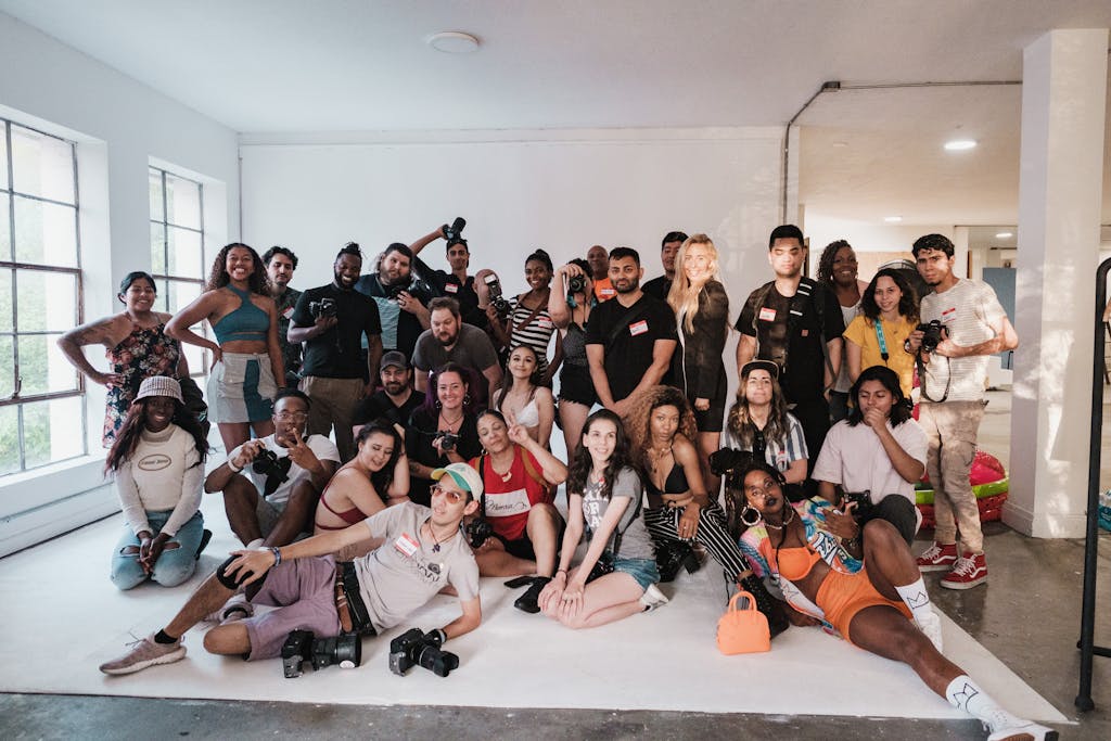 Large group of diverse photographers gathered in a bright studio space.